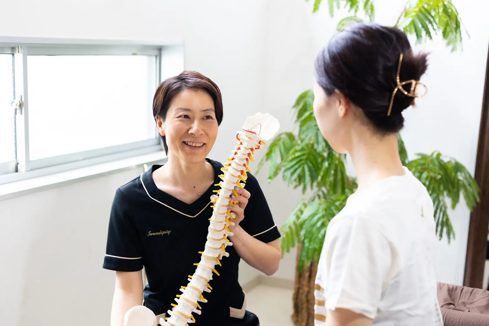 スタッフが背骨の模型を使ってお身体の状態をご説明している様子